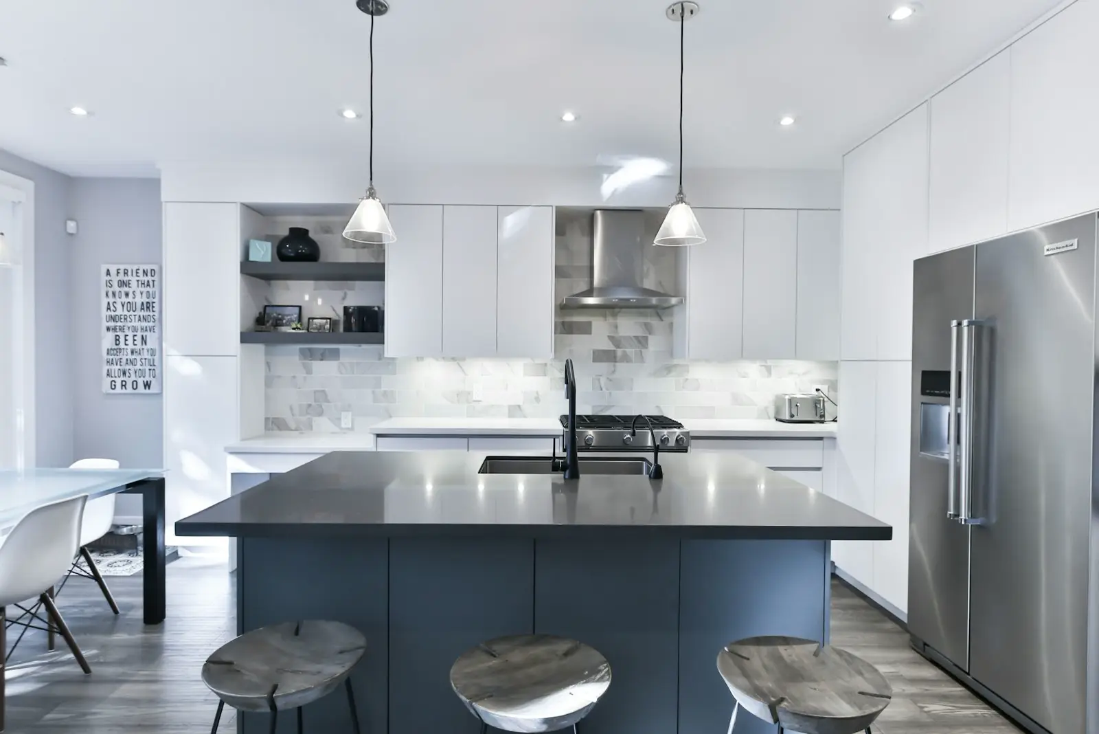 Cozinha remodelada com ilha central e bancos.